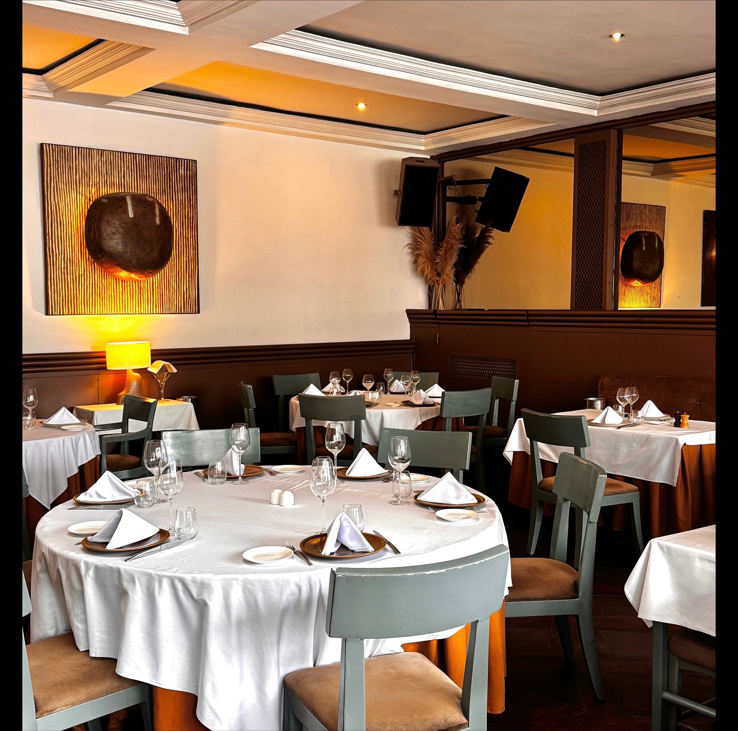 Salle de restaurant — art contemporain et tables dressées